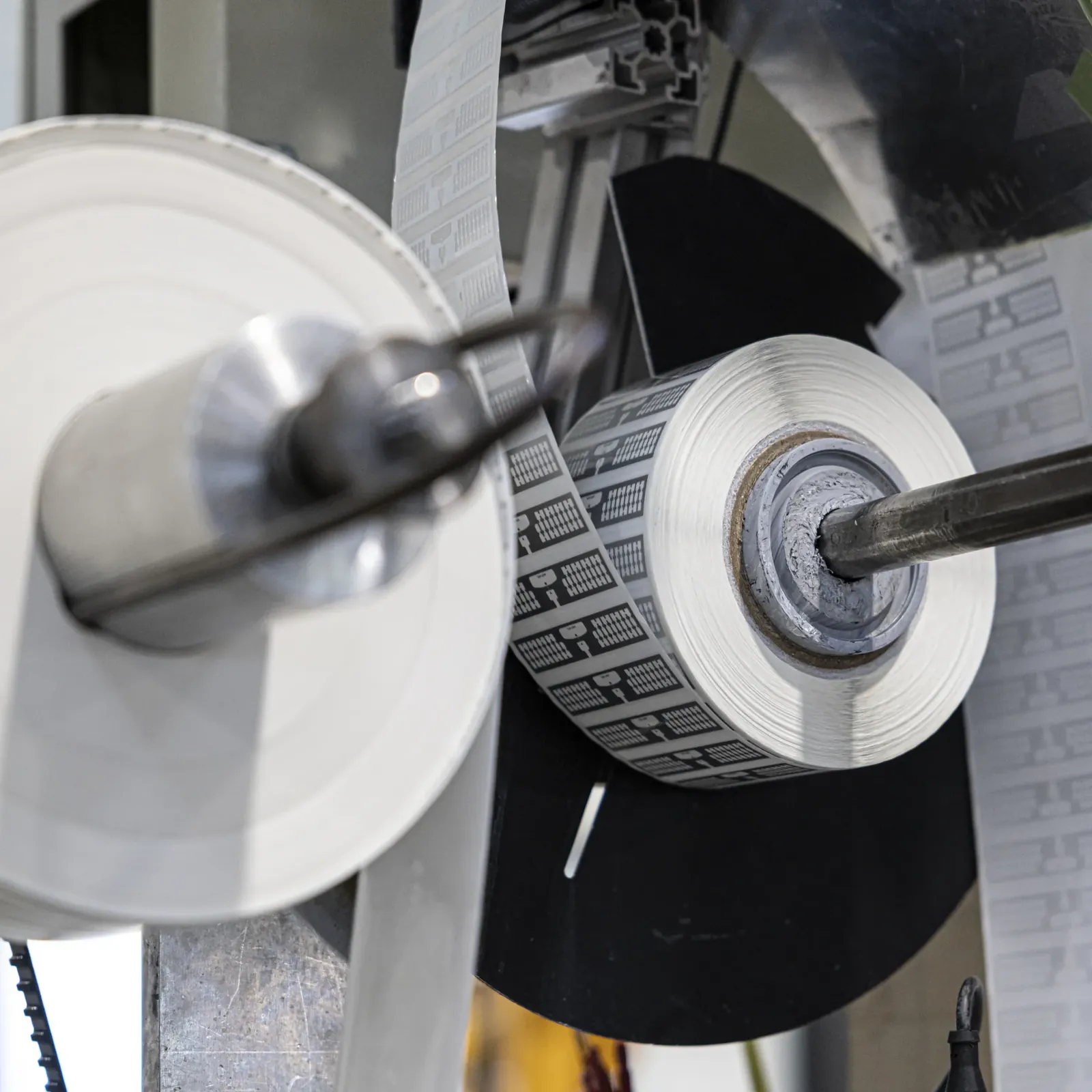 Bande d'inlays RFID s'enroulant sur l'axe d'une machine d'insertion