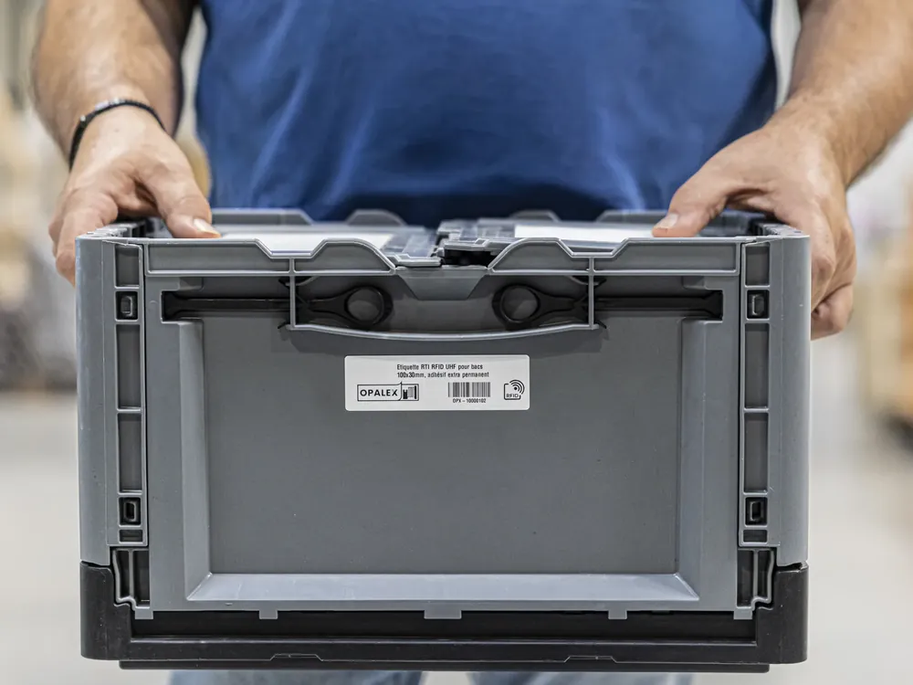 Étiquette RFID UHF Opalex posée sur un bac de manutention gris