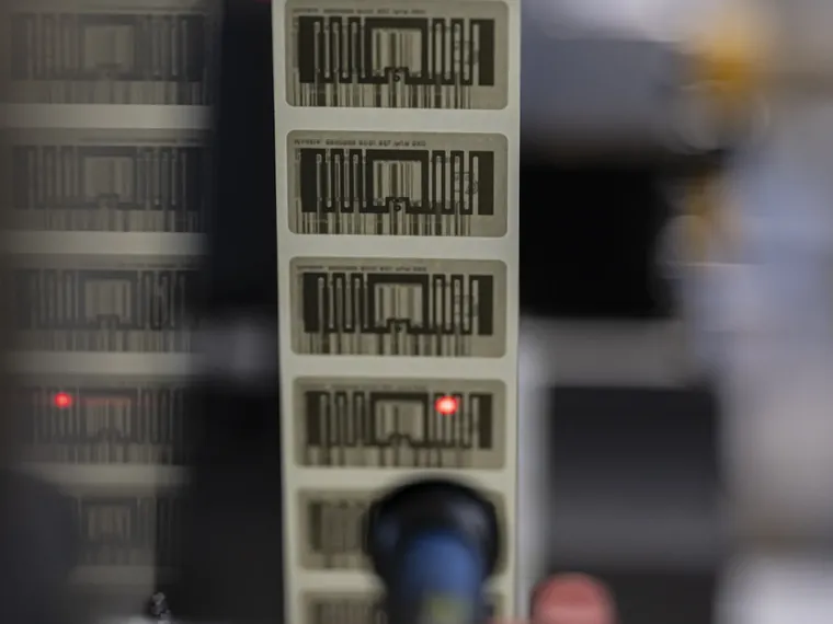 Bande d'étiquettes RFID défilant sous le contrôle laser