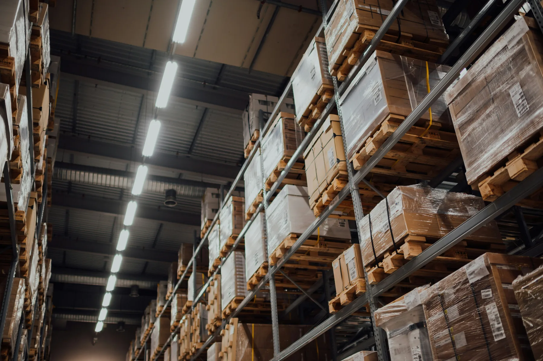Palettes filmées stockées en racks dans un entrepôt